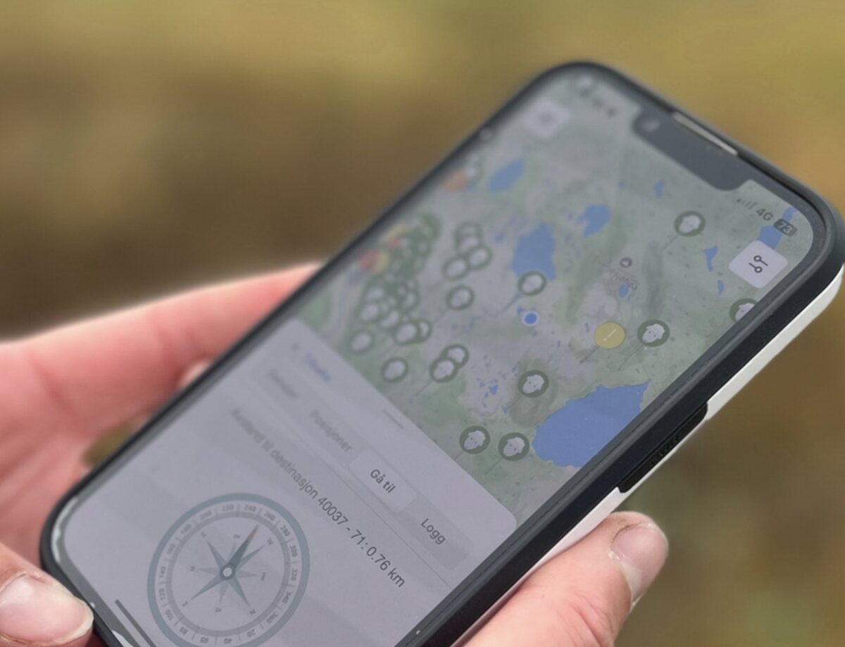 Findmy-appen i hånda på fjellet, med kart og retning til dyret