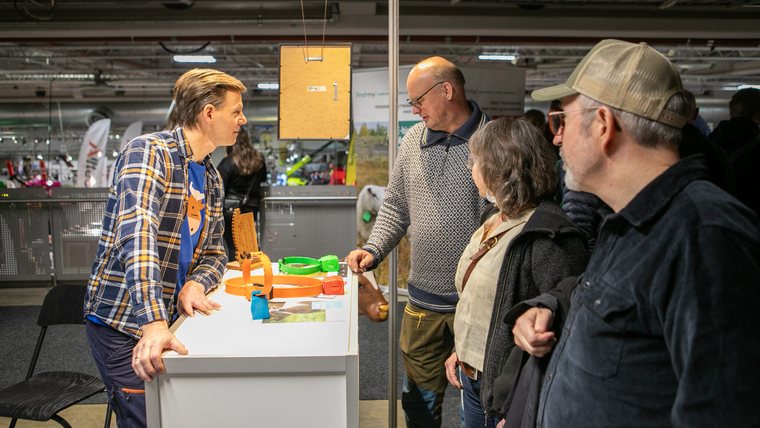 Findmy in conversation with farmers at a trade fair booth