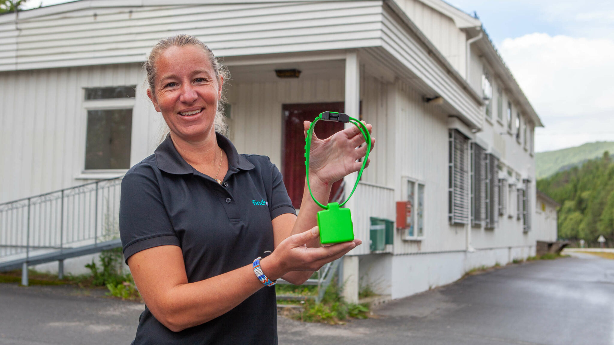 Findmy employee with a green e-bell outside the office in Kvikne